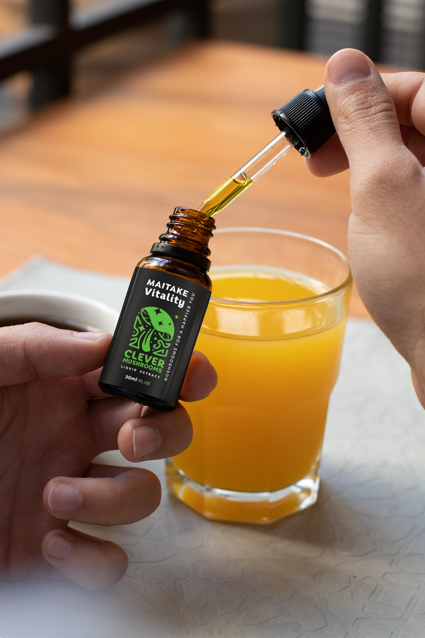 maitake mushroom tincture in dropper bottle being added to orange juice - clever mushrooms